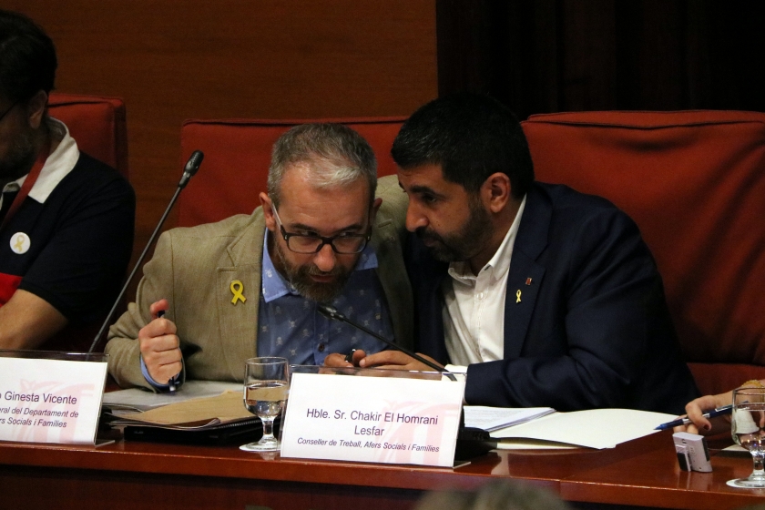  El conseller El Homrani conversa amb Josep Ginesta, secretari general de Treball, Afers Socials i Famílies, durant la compareixença a la Comissió de Treball, Afers Socials i Famílies del Parlament / ACN 
